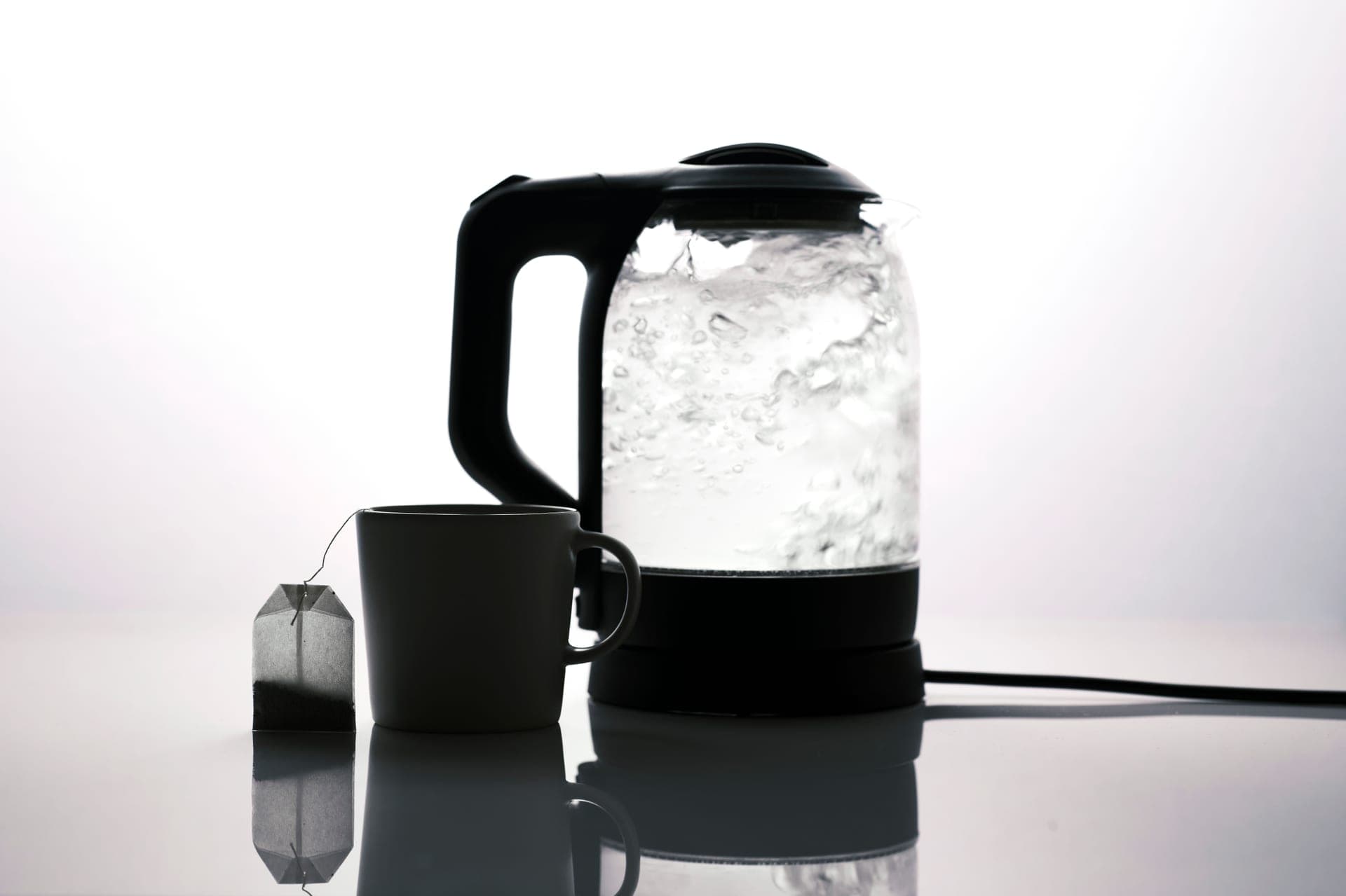 Modern electric kettle beside a mug of tea