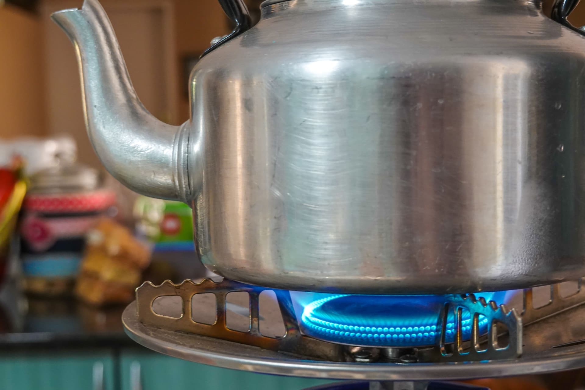 Whistling kettle on a gas hob with steam rising