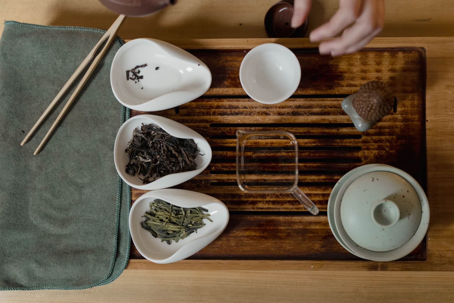 Loose leaf tea beside simple brewing gear on a kitchen surface