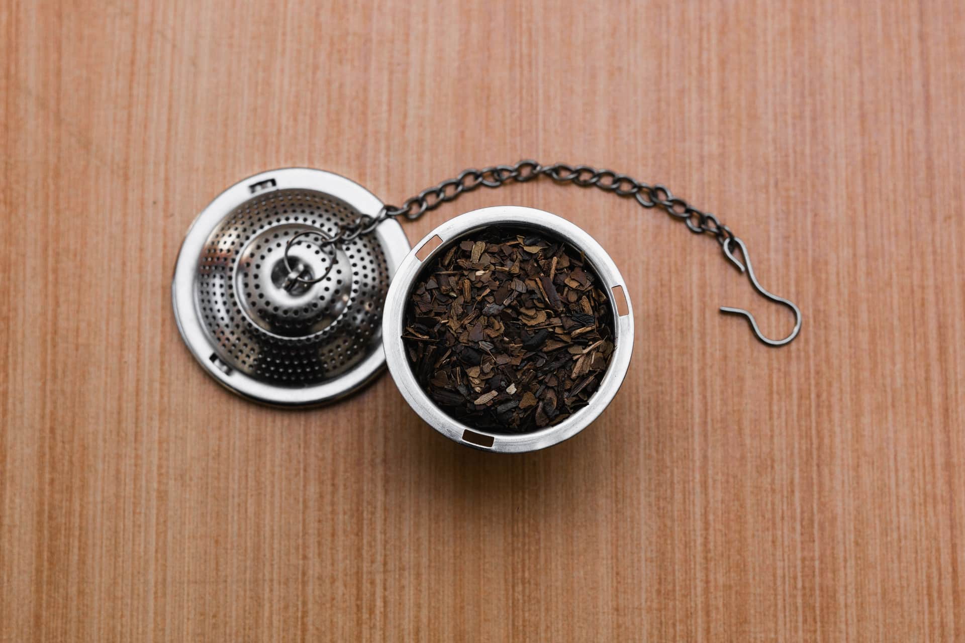 Tea leaves unfolding inside a stainless mesh infuser basket
